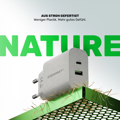 Strohfarbenes GREENMNKY Ladegerät mit USB C und USB A Port auf grünem Gitter, oben der Text Aus Stroh gefertigt und groß das grüne Wort NATURE